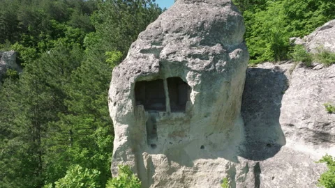 Ancient rock-carved chamber with rectangular opening nestled in limestone 스톡 동영상 308194630