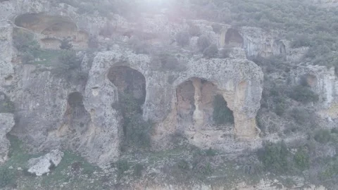 Ancient Rock-Cut Tombs and Caves on Steep Cliff - 4K Stock Footage 331821533