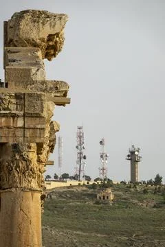 Ancient Roman columns tower over a hillside dotted with modern telecommunic.. Stock Photos