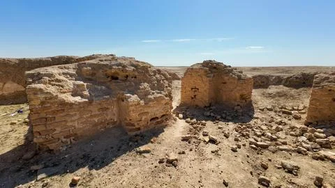 Ancient ruins of a brick structure in a desert landscape under a clear blue.. Fotos de archivo