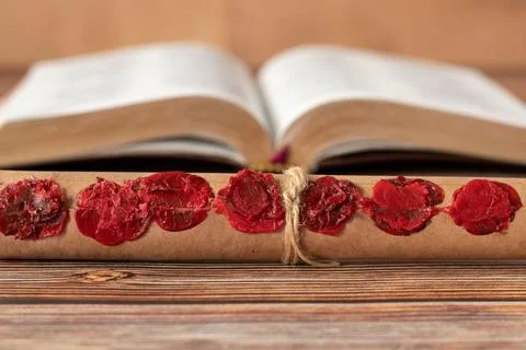 Ancient scroll with seven seals in front of an open holy bible book, closeup Stock Photos