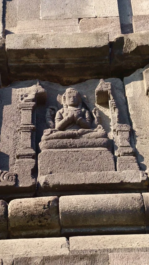 Ancient seated deity relief carved into a weathered stone niche on the sacr.. Vídeo Stock 341544968