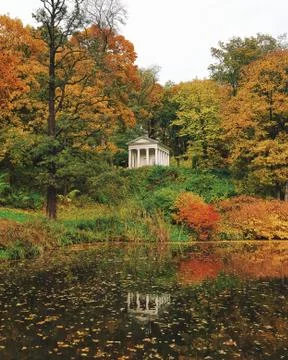 Ancient small building between trees, autumn, lake Stock Photos
