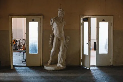 Ancient statue of apolon between two doorways. An old statue. Stock Photos