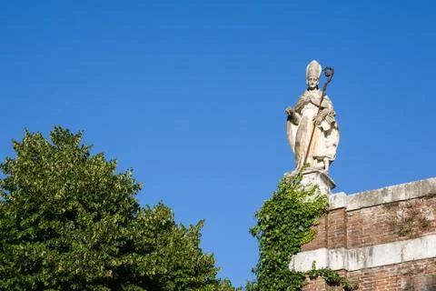 Ancient Statue of a Bishop Looking Down from a Medieval Wall Stock Photos