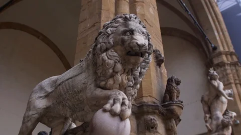 An ancient statue of a stone marble lion that holds a paw on a small ball. Stock Footage 111282805