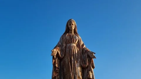 An ancient statue of the Virgin Mary under a clear blue sky. Stock Footage 336800000