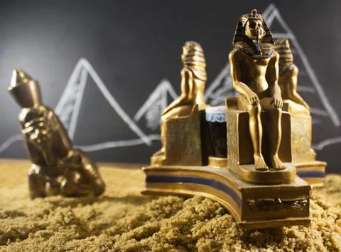 Ancient statuettes on sand. Stock Photos