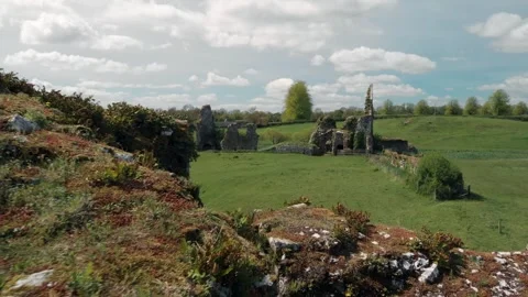 Ancient stone abbey ruins standing stoically in a lush green Irish countrys.. Stock Footage 341353008