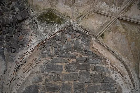 Ancient stone arch with exposed masonry and weathered plaster in historic m.. Stock Photos