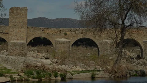 Ancient stone bridge with multiple arches crossing a river Stock Footage 335461274