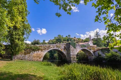 Ancient stone bridge spanning river under blue sky Stockfoto's