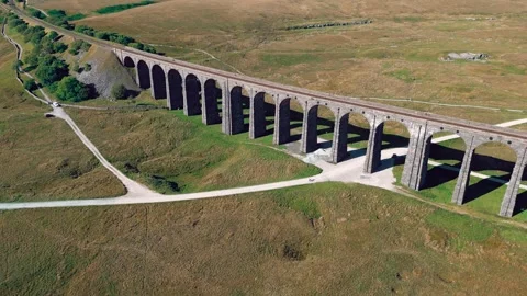 Ancient stone bridge stretches across golden grasslands. Yorkshire Dales,  .. Stock Footage 346296866