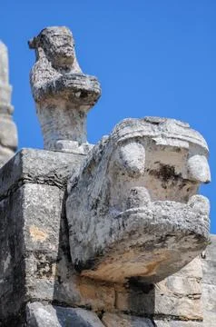 Ancient stone carvings of Chichen Itza under a clear blue sky Foto stock