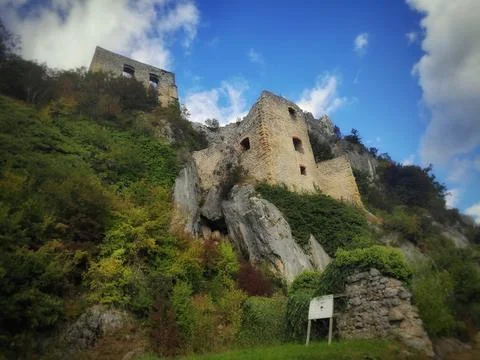 Ancient Stone Castle Surrounded by Greenery Under Blue Sky Foto stock