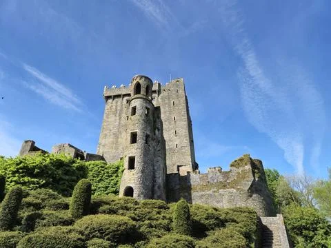 Ancient stone castle tower under blue sky and clouds Stock Photos
