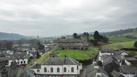 Ancient stone church rises above clustered village rooftops Vidéo 345651985