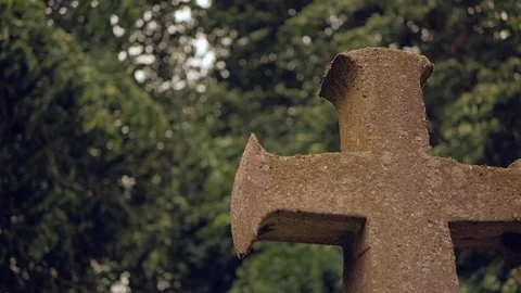 Ancient stone cross against the background of fluttering tree branches Stock Footage 111946421