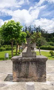 Ancient stone cross monument surrounded by trees in Asturias Spain 스톡 사진