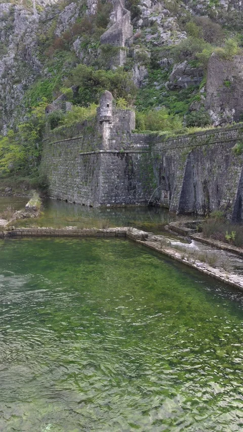 Ancient stone fortifications alongside a green body of water. Stock Footage 312514947
