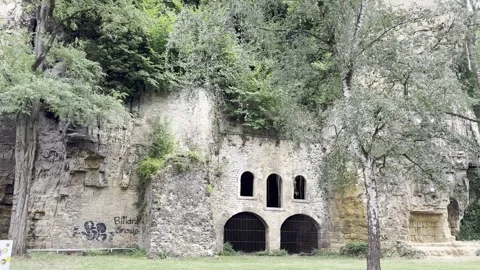 Ancient stone fortifications and rock walls with arched barred windows. Video stock 345413958