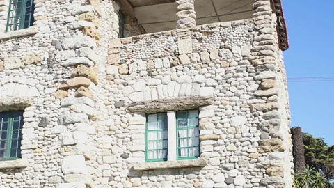 Ancient stone house with bars in windows against the blue sky Stock Footage 130001722
