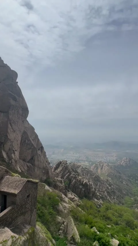 Ancient stone hut perched on a rugged mountain cliffside Vídeos de archivo 334084957