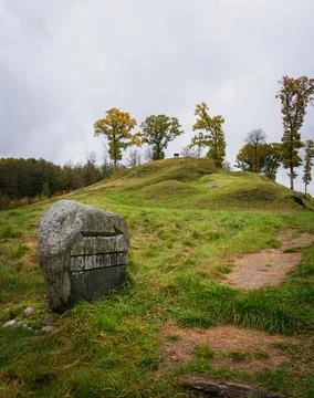 Ancient stone marker on grassy hill with trees Foto stock