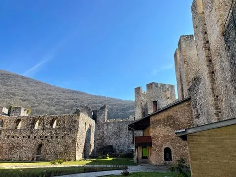 An ancient stone monastery set against a backdrop of a clear blue sky Foto stock