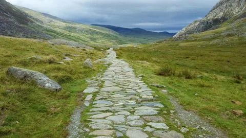 Ancient stone path through a beautiful rugged landscape in Wales. Stock Photos