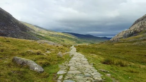 Ancient stone path through a beautiful rugged landscape in Wales. Includes space Stock Photos