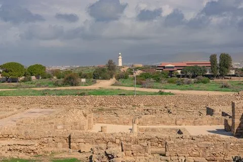 Ancient stone ruins with a distant lighthouse in Paphos Stock Photos