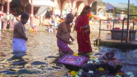 Ancient stone Shivling with devotees taking holy bath at sacred Godavari river Video stock 311173057