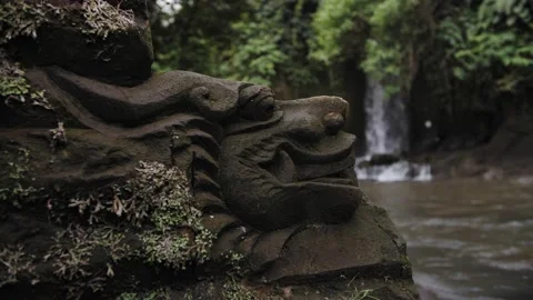 Ancient stone statue against the backdrop of a waterfall in Bali Stock Footage 222621162