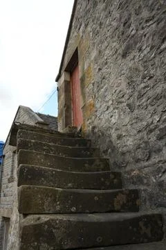 Ancient Stone Steps And Rustic Red Door On Old Building In Hartington, England. Stock Photos