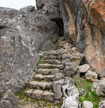 Ancient Stone Steps Leading Through a Rocky Mountain Passage 스톡 사진