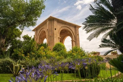 Ancient Stone Structure in Lush Green Garden with Flowers Stock Photos