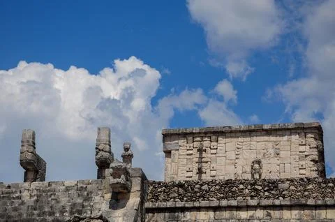 Ancient stone structures of Chichen Itza under a vibrant sky with clouds Stock Photos