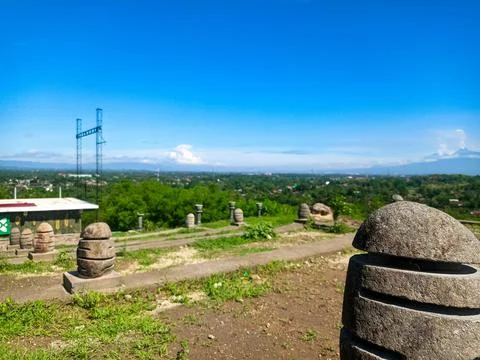 Ancient stone structures on a hill overlooking a city landscape with distan.. Stock Photos