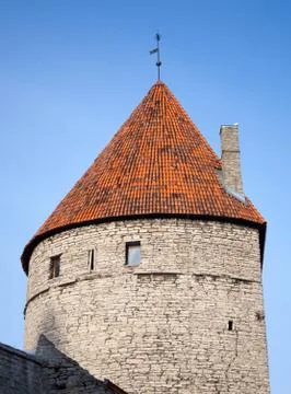 Ancient stone tower with red tiled roof. Fortress in old town of Tallinn, Est Stock Photos