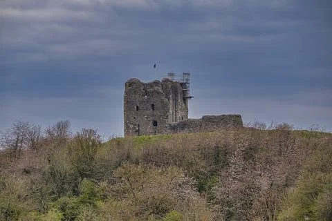Ancient stone tower stands atop a grassy hill Stock Photos