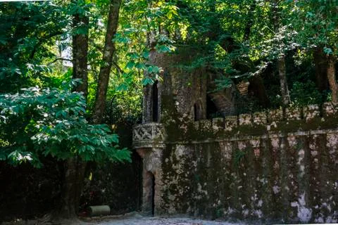 Ancient stone tower surrounded by trees and greenery Stock Photos