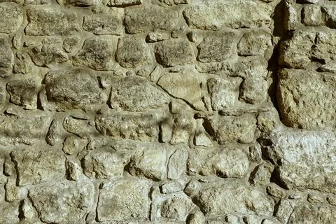 Ancient Stone Wall Consisting of Textured Boulders With Natural Light Casti.. Stock Photos
