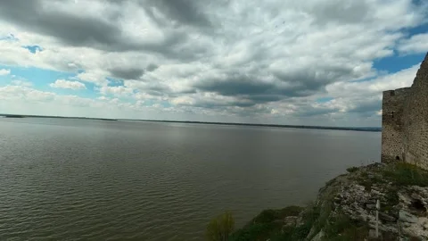 Ancient stone wall overlooks vast, calm water. Ram Fortress, Serbia Видео 332543535