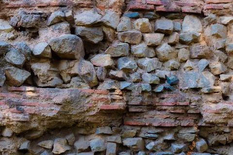 Ancient stone wall showcasing weathered bricks and natural stones in a hist.. Stock Photos