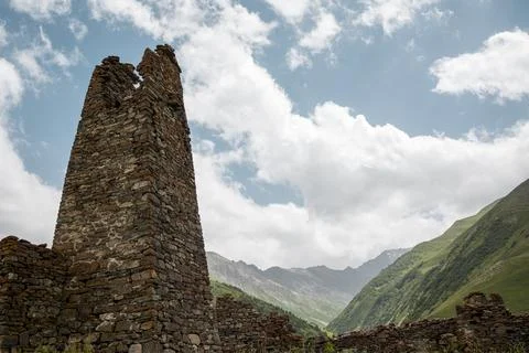 Ancient stone watch tower on background of Caucasus Mountains Stock Photos