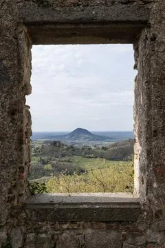 Ancient stone window framing scenic mountain landscape view 库存照片