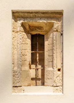 An ancient stone window with a window grid. Stock Photos