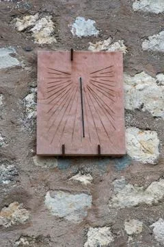 Ancient sundial placed on an old stone wall Stock Photos