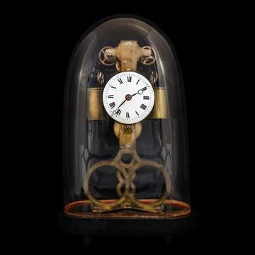 Ancient table clock inside a bell jar isolated on a black background Stock Photos